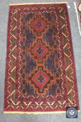 An Iranian rug, with three red medallions on a midnight blue field,