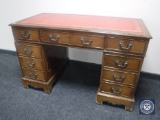 A reproduction mahogany twin pedestal writing desk with tooled leather panel
