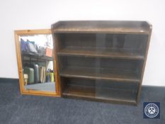 A 20th century oak sliding door bookcase and a pine framed mirror