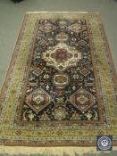 A fringed Persian woollen rug of geometric design