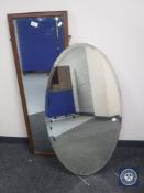 A large oval framed mirror and a hall mirror