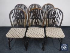 A set of six oak wheel back dining chairs