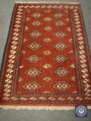 A fringed Persian design rug on red ground,