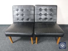 A pair of mid 20th century blacked buttoned vinyl chairs on teak legs