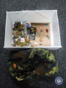 A box of assorted metal military badges and buttons