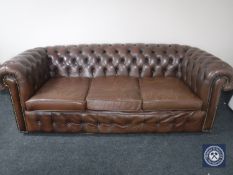 A brown buttoned leather Chesterfield three seater settee