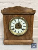 An inlaid oak cased French mantel clock by Maple & Co.