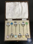 A set of six cased silver and enamel coffee spoons
