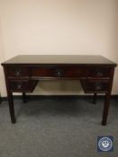 A Chinese hardwood writing desk fitted with five drawers with glass top, width 122 cm.