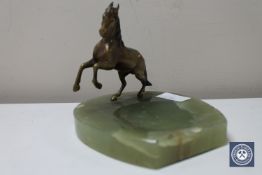 An onyx ashtray surmounted with a gilt metal figure of a horse