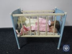 A mid 20th century doll's metal cot and two dolls