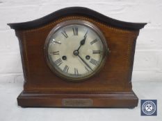An inlaid mahogany mantel clock with silvered dial