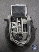 A camera backpack containing an Olympus digi SLR and an Olympus OM707 with accessories