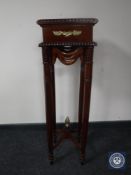 A reproduction mahogany torchere with ormolu mounts