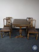 An early 20th century oak pull out dining table together with four chairs