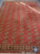 A 20th century machine made Persian design carpet on red ground