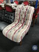 A button back bedroom chair in multi coloured striped fabric.