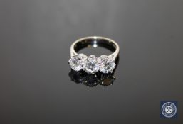 An 18ct white gold three-stone diamond ring, three brilliant-cut stones within raised claw settings,