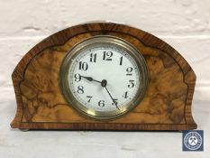 An inlaid burr walnut cased French mantel clock raised on brass feet,