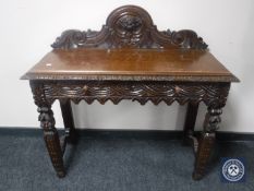 An early 20th century heavily carved oak hall table