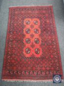 A Turkmen rug, North Afghanistan, the claret field with eight guls enclosed by narrow borders,