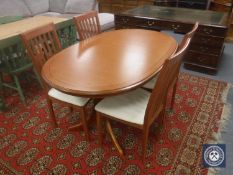 A teak G Plan oval extending table and four rail back chairs