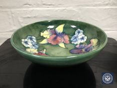 A Moorcroft floral pattern bowl on green ground,