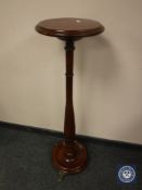 A turned mahogany jardiniere stand on paw feet, height 107 cm.
