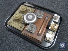 A tray containing a gilt metal desk stand, Edwardian oak desk stand, two glass inkwells, coins,