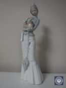 A Lladro figure of a lady with a parasol carrying a dog, height 38cm.