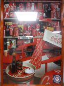A framed 1980's Coca Cola poster