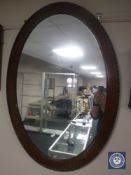 An antique mahogany oval framed mirror