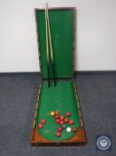 An early 20th century folding bar billiards table with later balls and cues