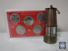 A miniature copper and brass oil lamp and a set of 1979 Isle of Man coins