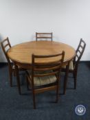 A circular teak G-plan dining table together with a set of four ladder back chairs