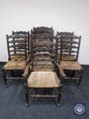 A set of seven rush seated ladder back country kitchen chairs