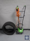 An electric garden rotovator and a car tyre