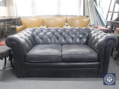 A pair of black button leather two seater Chesterfield settees (one with odd cushions)