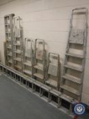 Seven aluminium step ladders and an extension ladder