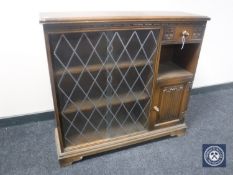 A set of oak sliding glass door bookshelves fitted a cupboard and a drawer