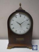 A 20th century inlaid mahogany mantel clock with lion mask handles by Comitti of London on brass