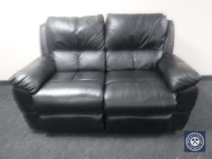 A black leather two-seater manual reclining settee