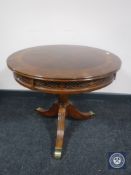 A circular mahogany occasional table on three-way pedestal support