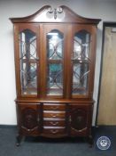 A contemporary mahogany display cabinet fitted cupboards and drawers beneath,