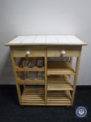 A pine tiled-top kitchen wine trolley fitted two drawers