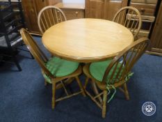 A circular oak pedestal kitchen table together with four chairs