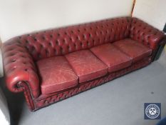 A red button leather four seater Chesterfield settee