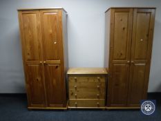 A pair of pine double door wardrobes together with a pine four-drawer chest