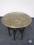 A folding Eastern brass topped table