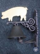 A cast metal pig wall bracket with bell
